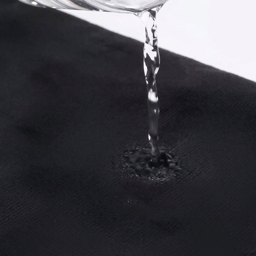 Water being poured onto a black microfibre towel